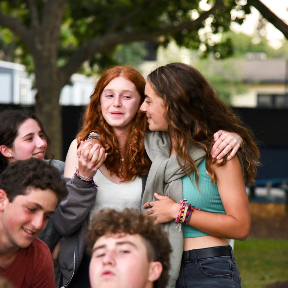 Two friends with arms around each other.