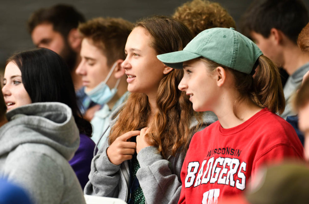 Campers sitting at a gathering and listening.