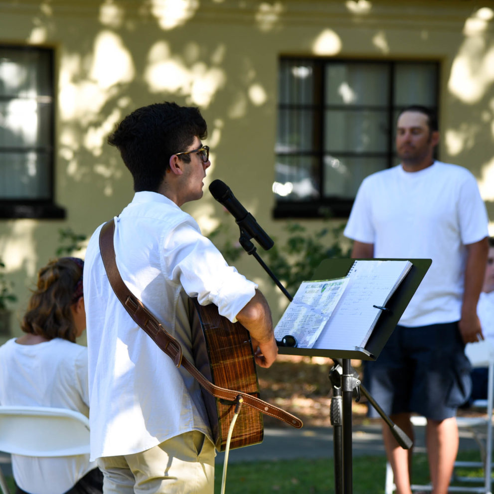 Man playing guitar at a Shabbat gathering.