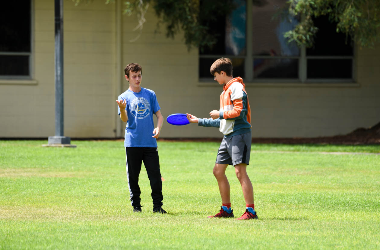 Friends playing frisbee together.