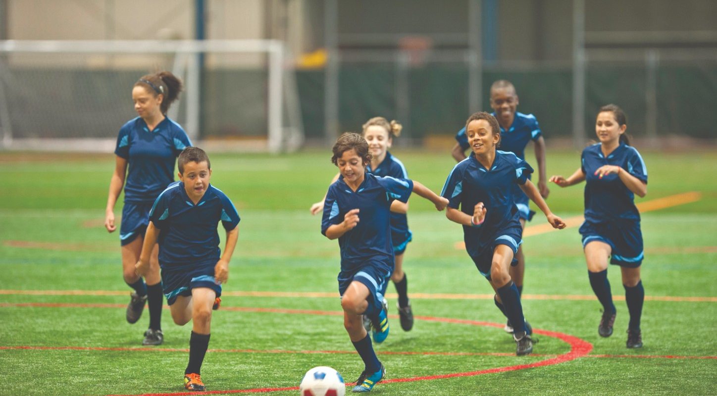 Boys and girls playing soccer together.