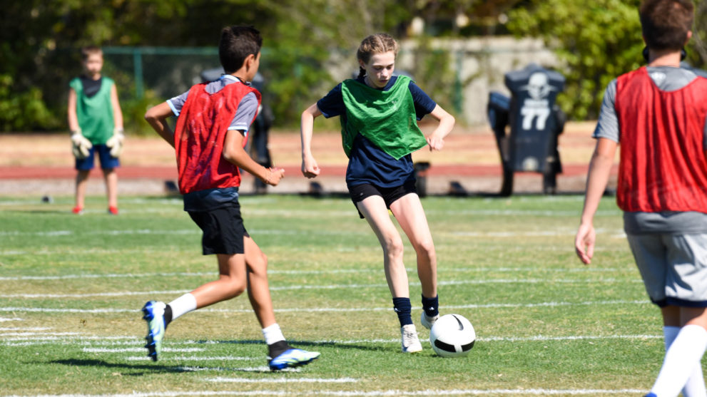 Soccer campers playing a game of soccer.