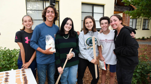 Teens hanging out making smores.