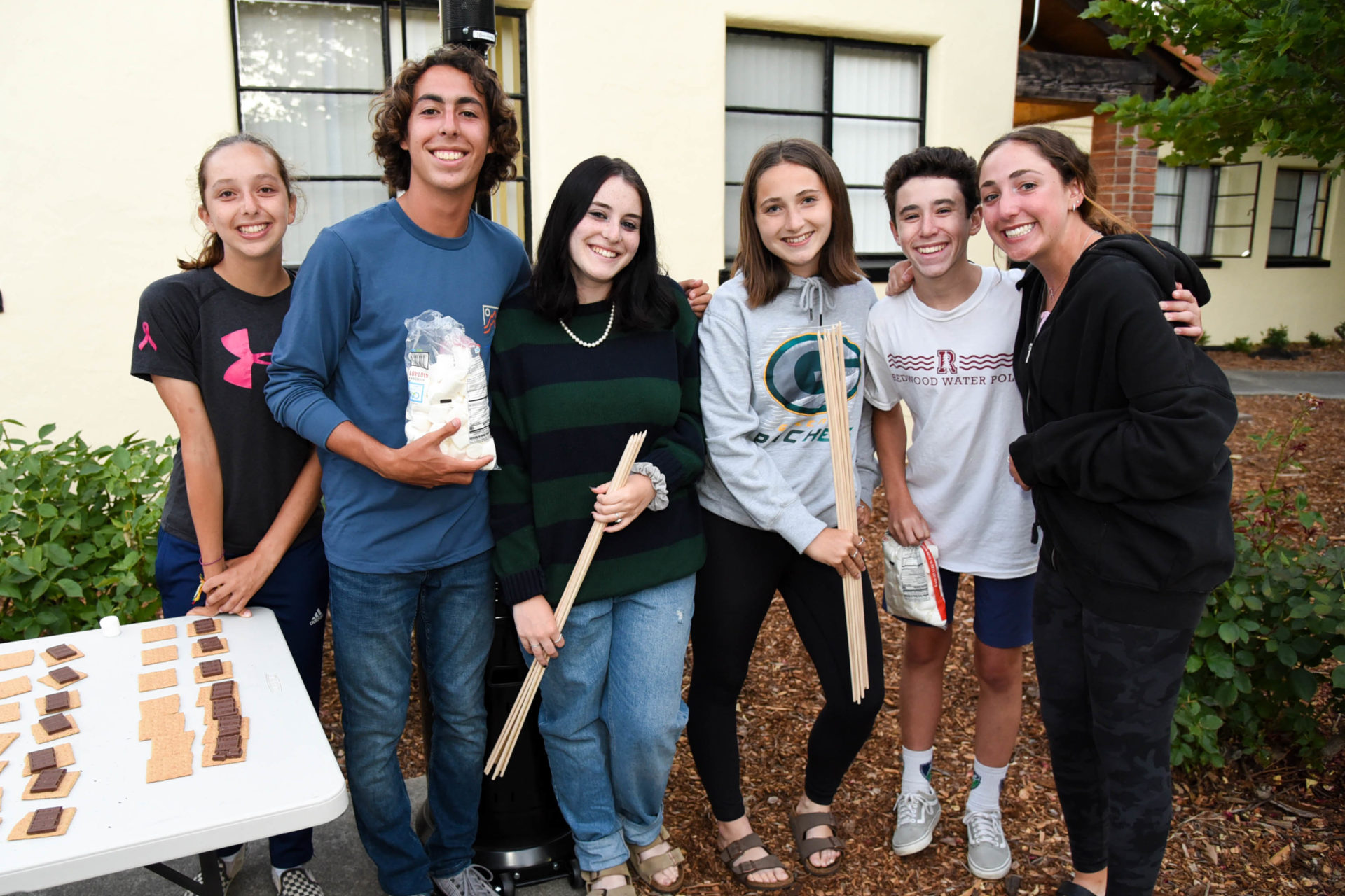 Teens hanging out making smores.