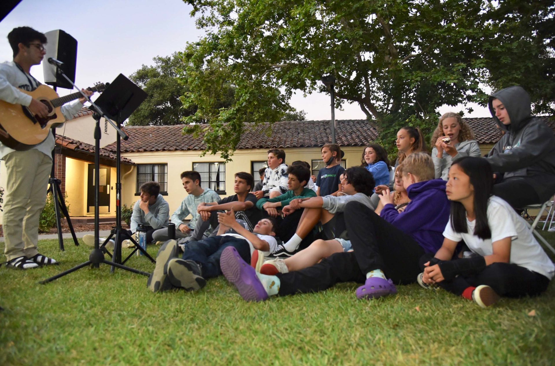 A camper singing in front of other campers.